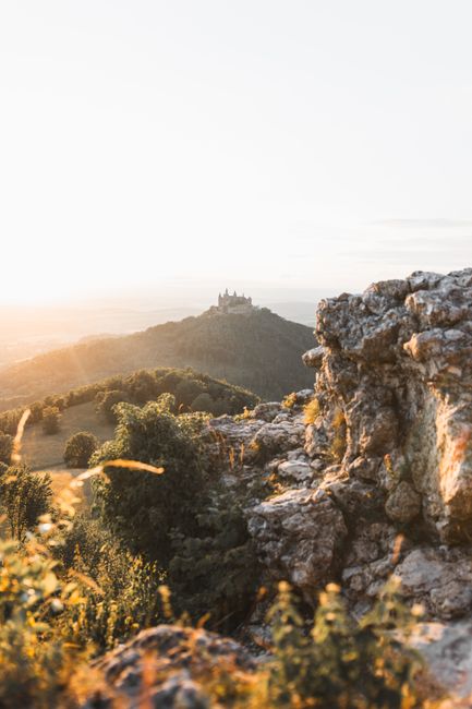 Stunning sunrise view of Burg Hohenzollern with rocky foreground, capturing the essence of German heritage.