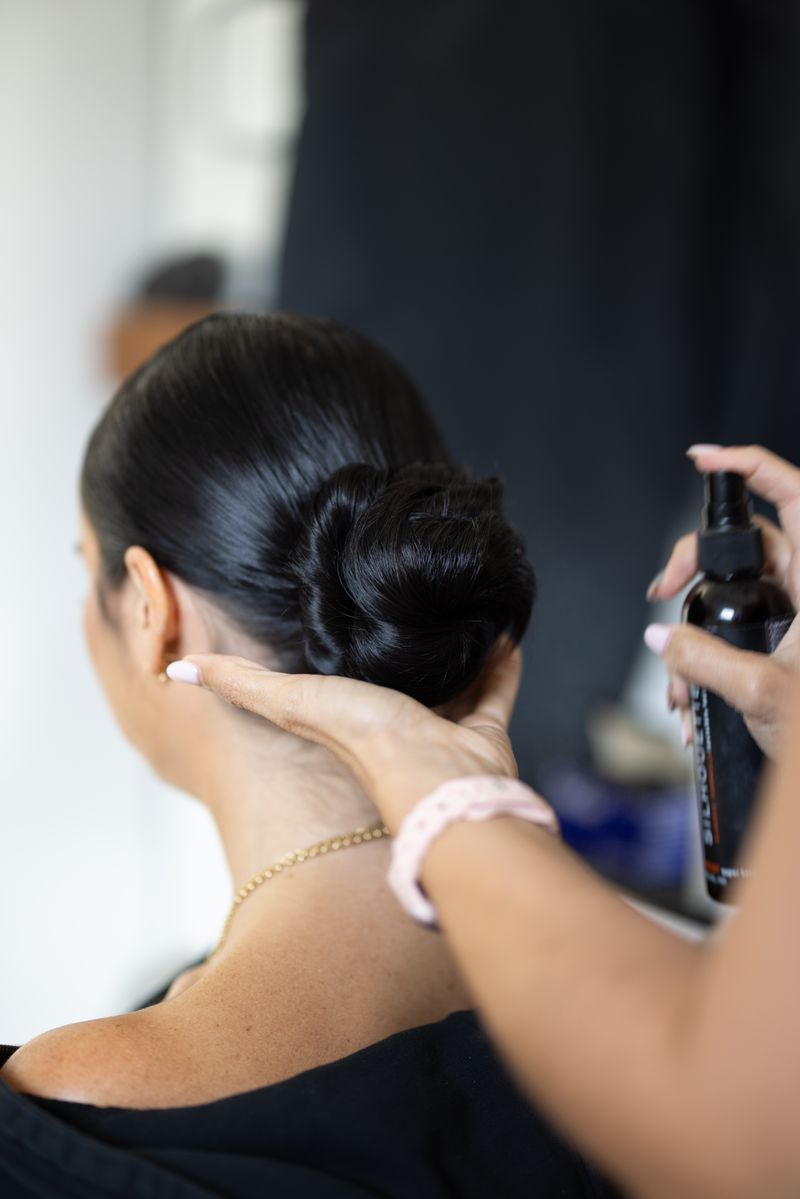 A stylist finishing a sleek updo
