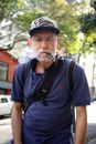 一位在圣保罗户外穿着休闲服装、戴着帽子抽烟斗的老人肖像