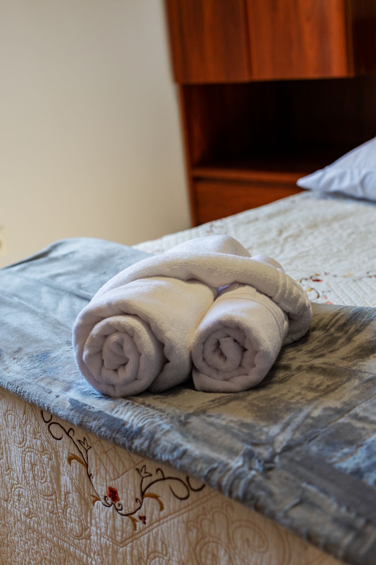 Asciugamani bianchi puliti e piegati con cura su un letto d’hotel