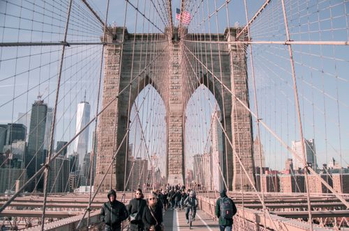 Free Bustling scene on Brooklyn Bridge with city skyline and pedestrians. Stock Photo