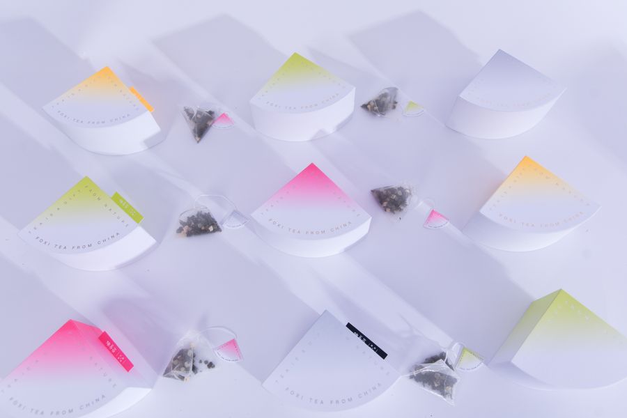 Tea packaging and tea sachets arranged on a white background