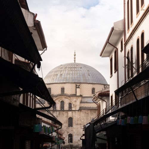 Free View of an Ottoman-style mosque dome between traditional buildings, showcasing classic architecture. Stock Photo