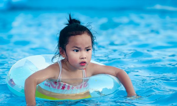 Young child with float ring at swimming pool