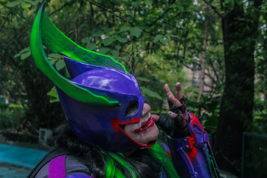 A creative and vibrant cosplay character showcasing colorful armor in an outdoor setting.