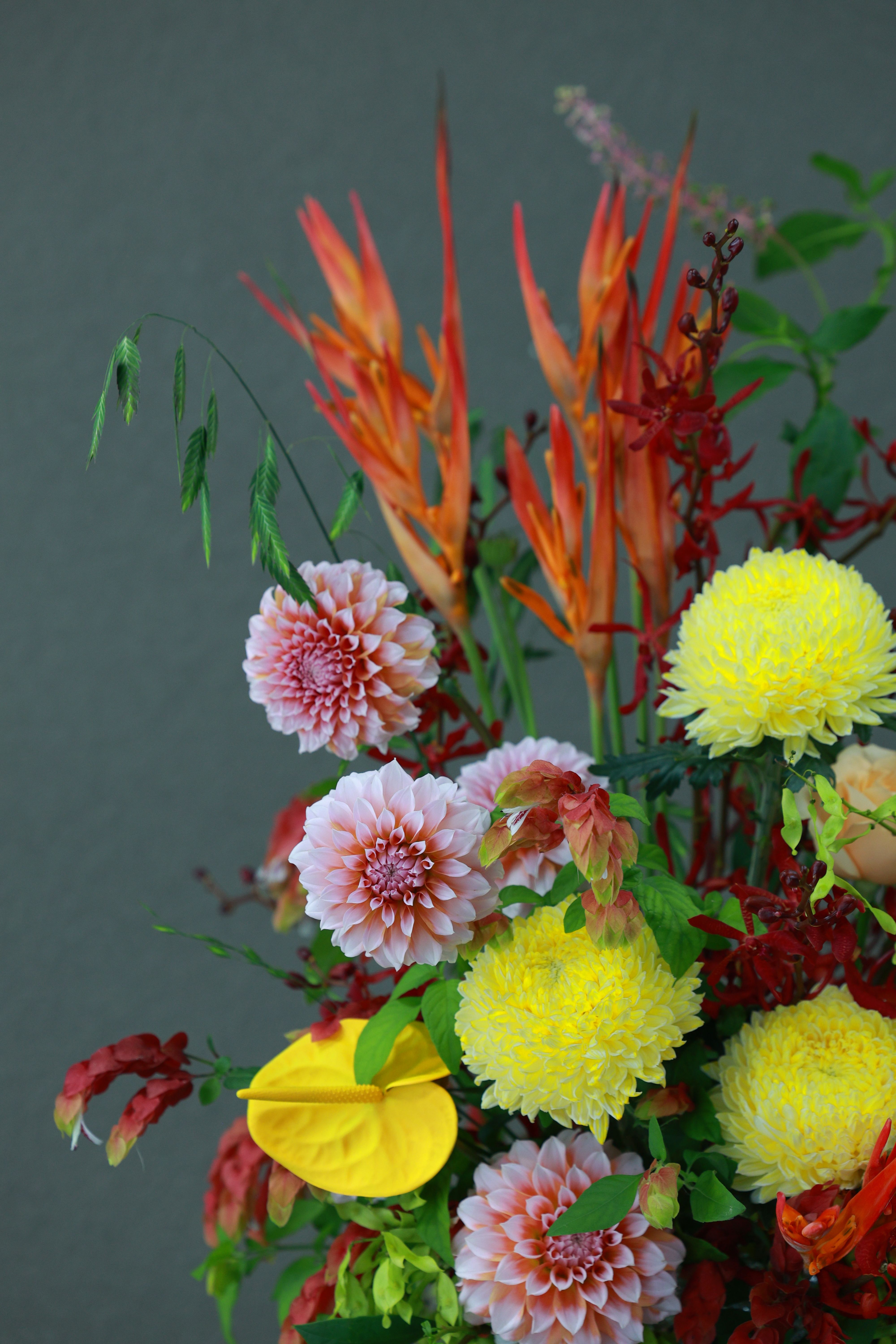 Bold red and orange flower bouquet with tropical foliage