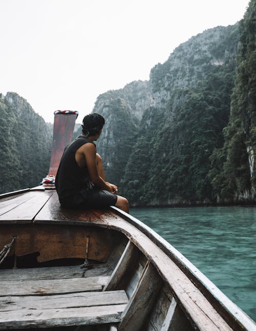 Man Sitting on Sailboat