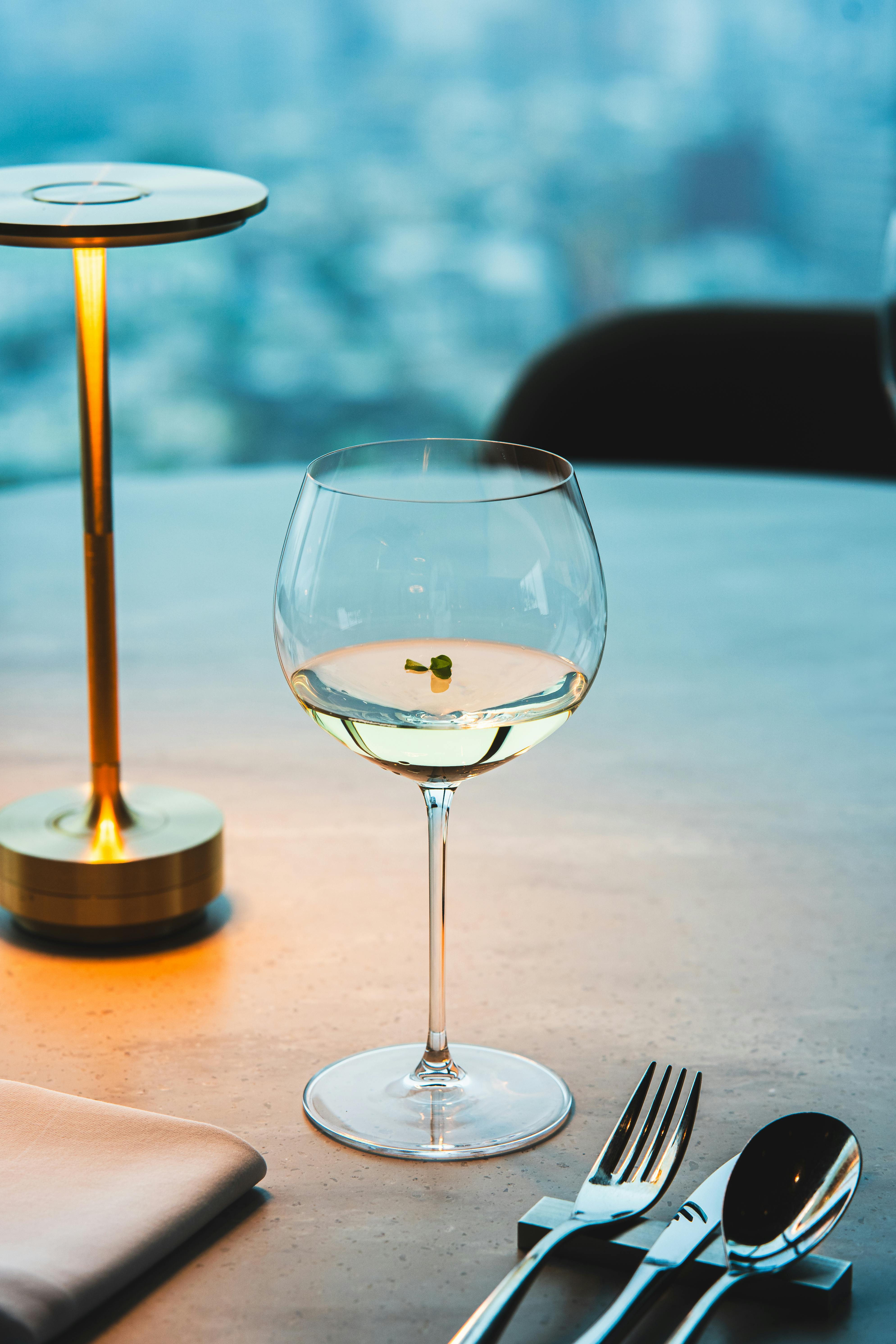 A stylish wine glass on a table overlooking a cityscape, captured in Tokyo.