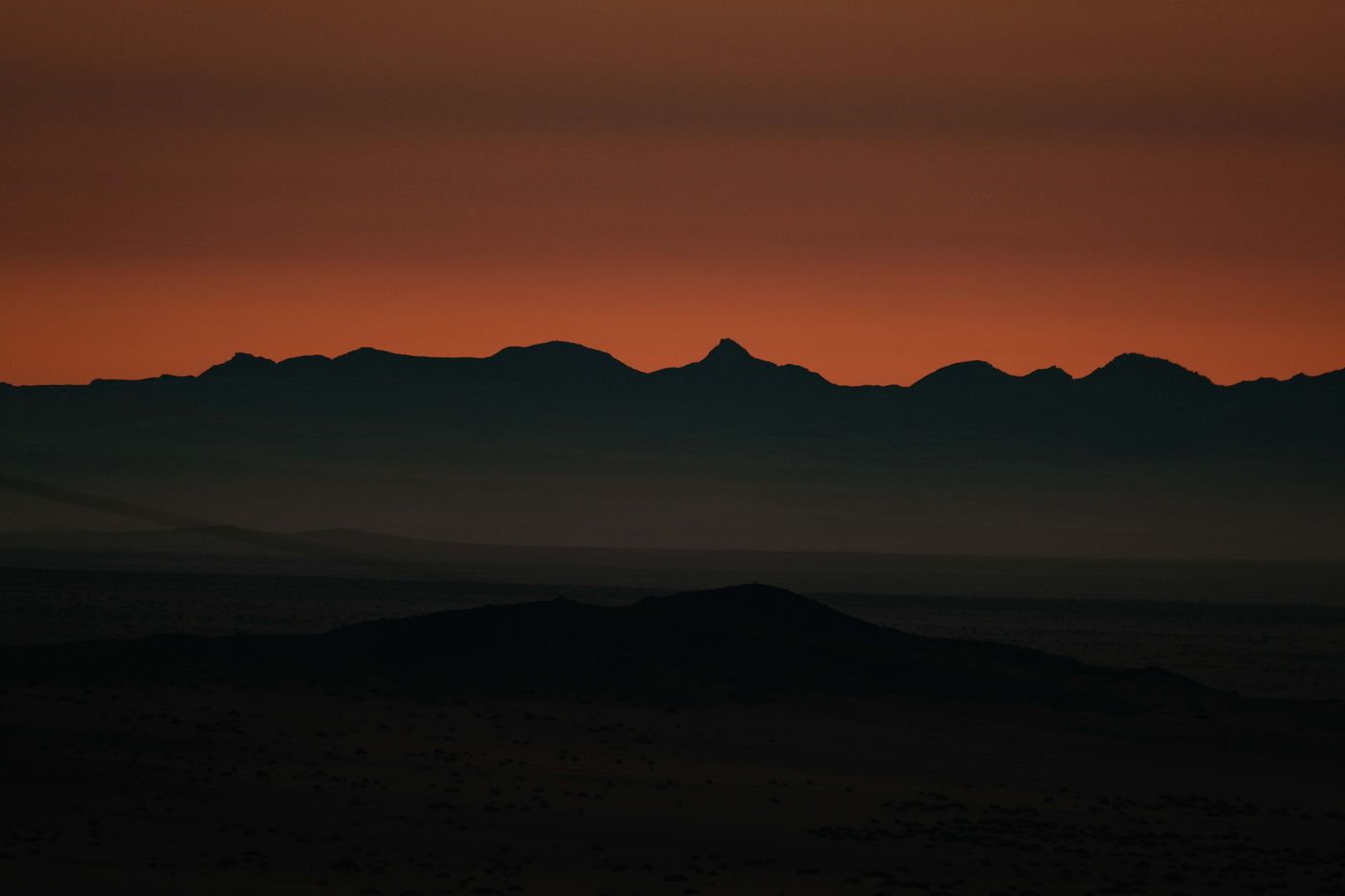 Mountain silhouettes under an orange twilight sky — photo by Francesco Ungaro on Pexels