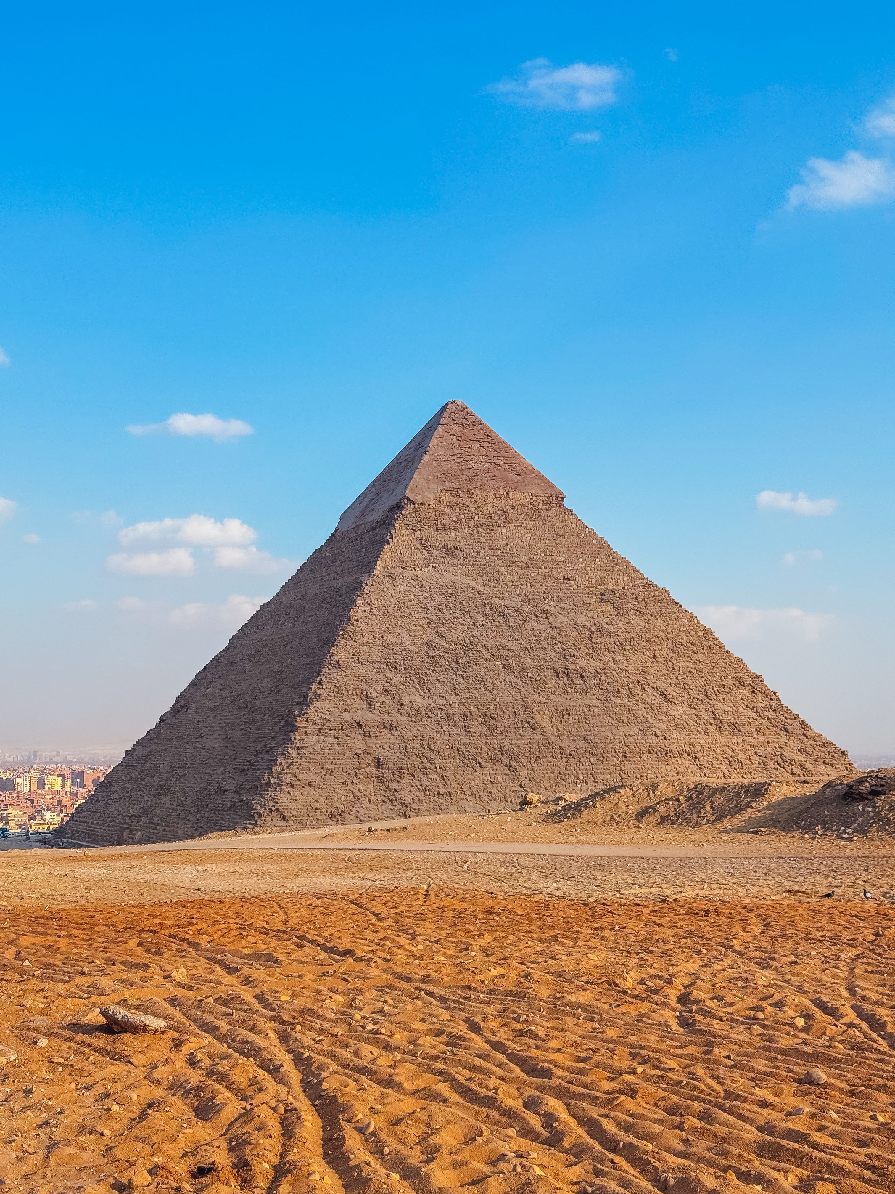 Majestic view of the Great Pyramid of Giza with clear blue skies, showcasing ancient Egyptian architecture.