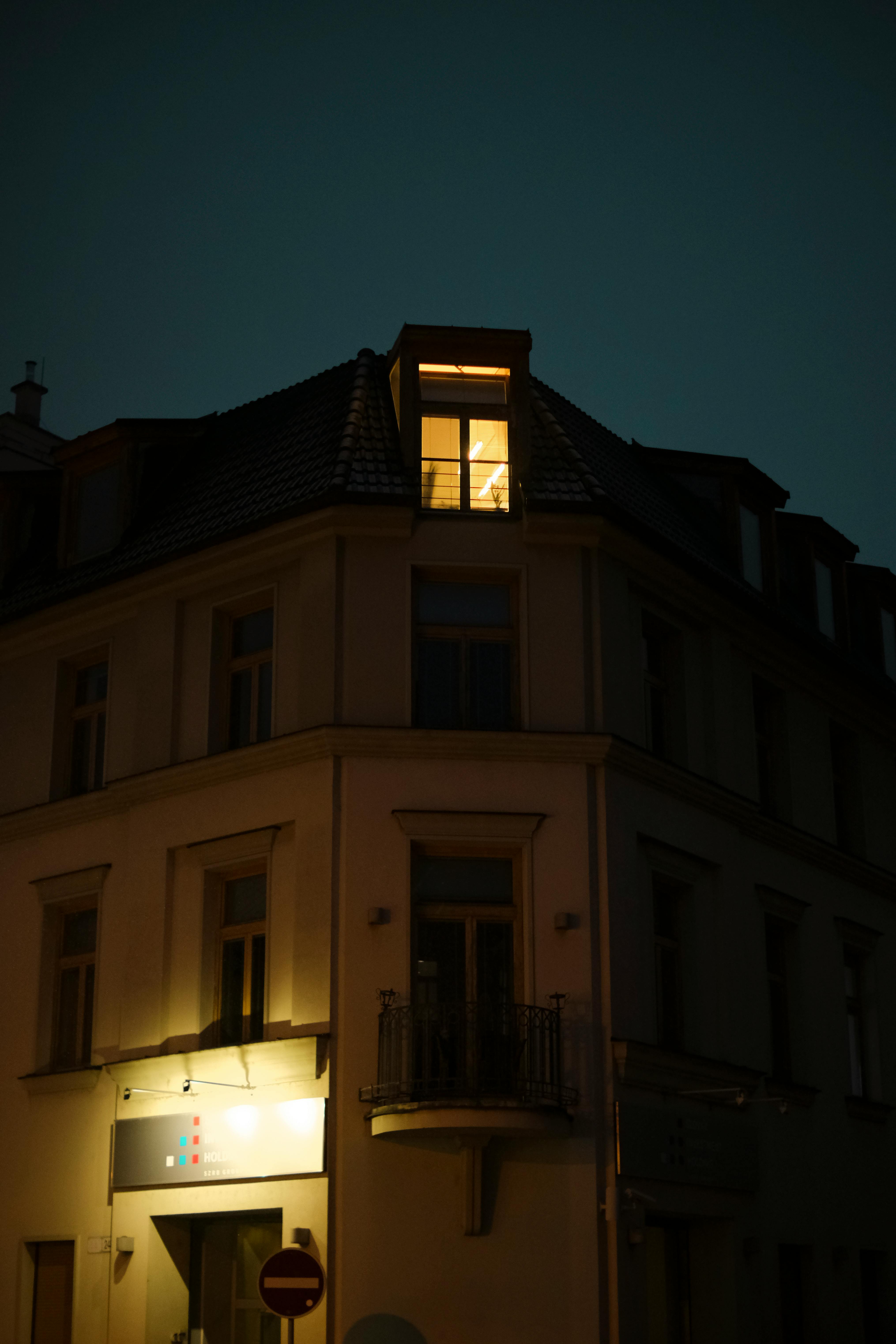 A dimly lit corner building at night creates a moody urban atmosphere in Bratislava.