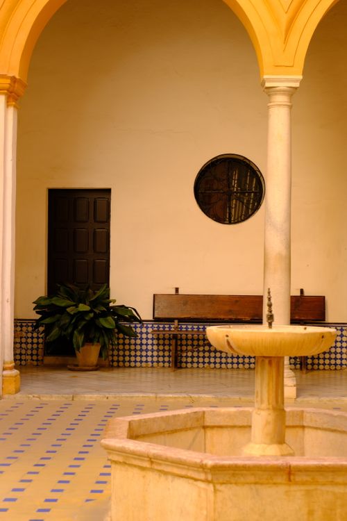 Free Tranquil Andalusian courtyard featuring a central fountain and classic architecture. Stock Photo