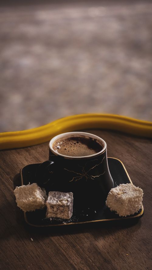 Free A cup of rich Arabic coffee served with Turkish delight on a wooden table. Stock Photo