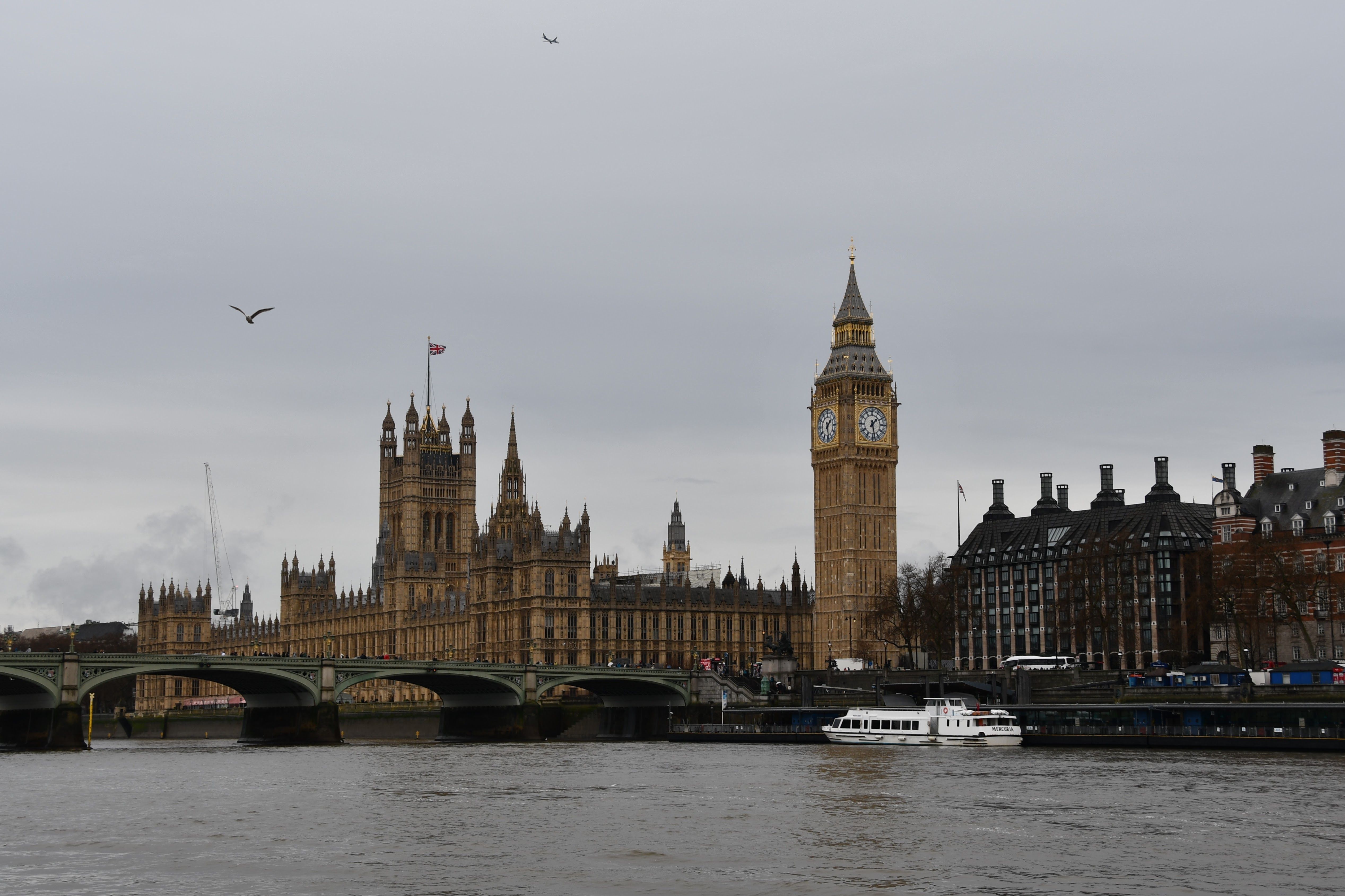 Towering Big Ben and Westminster Bridge over River Thames in London, UK.