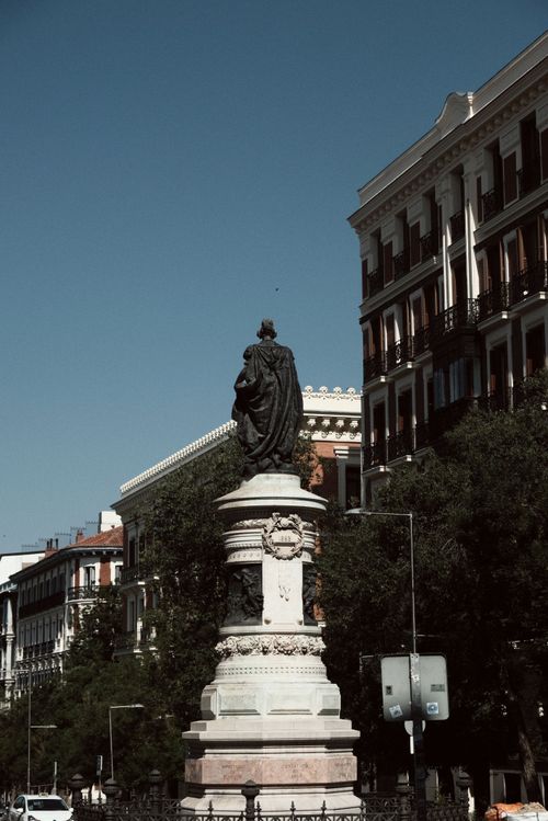 Free Explore the 19th-century statue and ornate buildings in Madrid, Spain. Perfect for travel and architectural imagery. Stock Photo