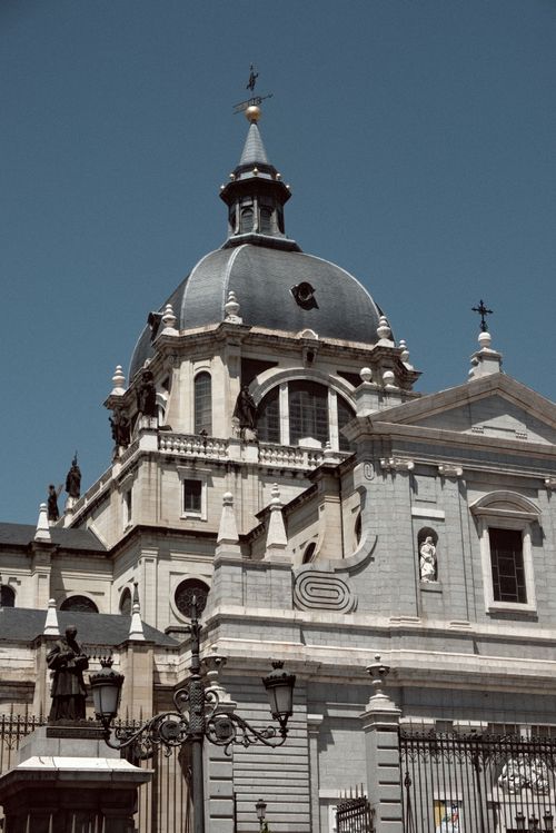 Free Stunning architectural details of Almudena Cathedral under a clear blue sky in Madrid, Spain. Stock Photo