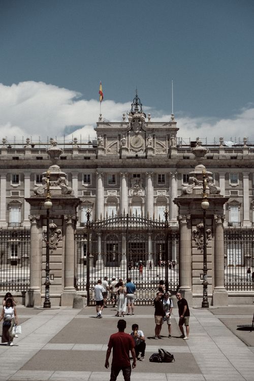 Free The historic Royal Palace of Madrid with tourists exploring the iconic landmark during summer. Stock Photo