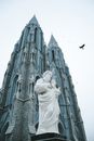 From below statue of St Joseph in front of tall historic catholic church in Gothic style located in Mysore of India