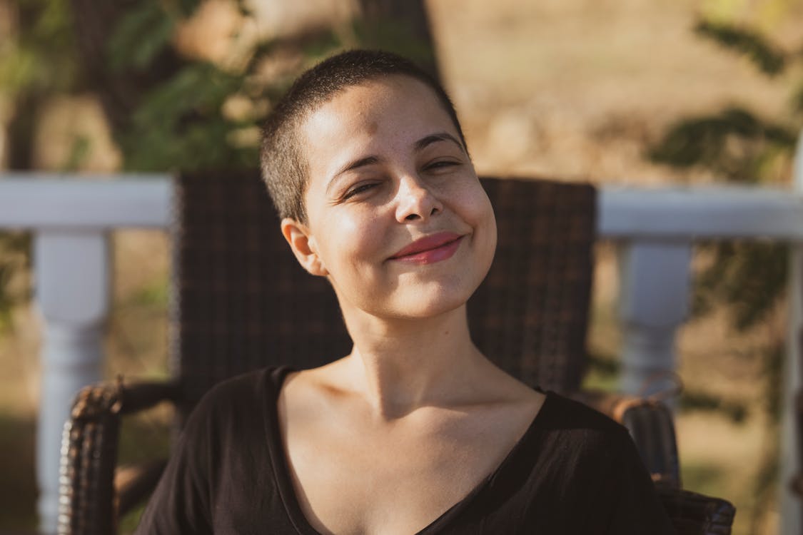 Woman Smiling While Standing Beside Fence