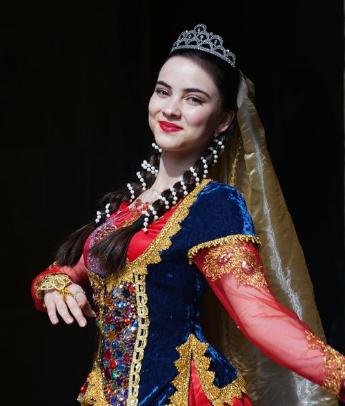Free A young woman in traditional Azerbaijani attire performs a cultural dance. Bright colors and intricate designs. Stock Photo