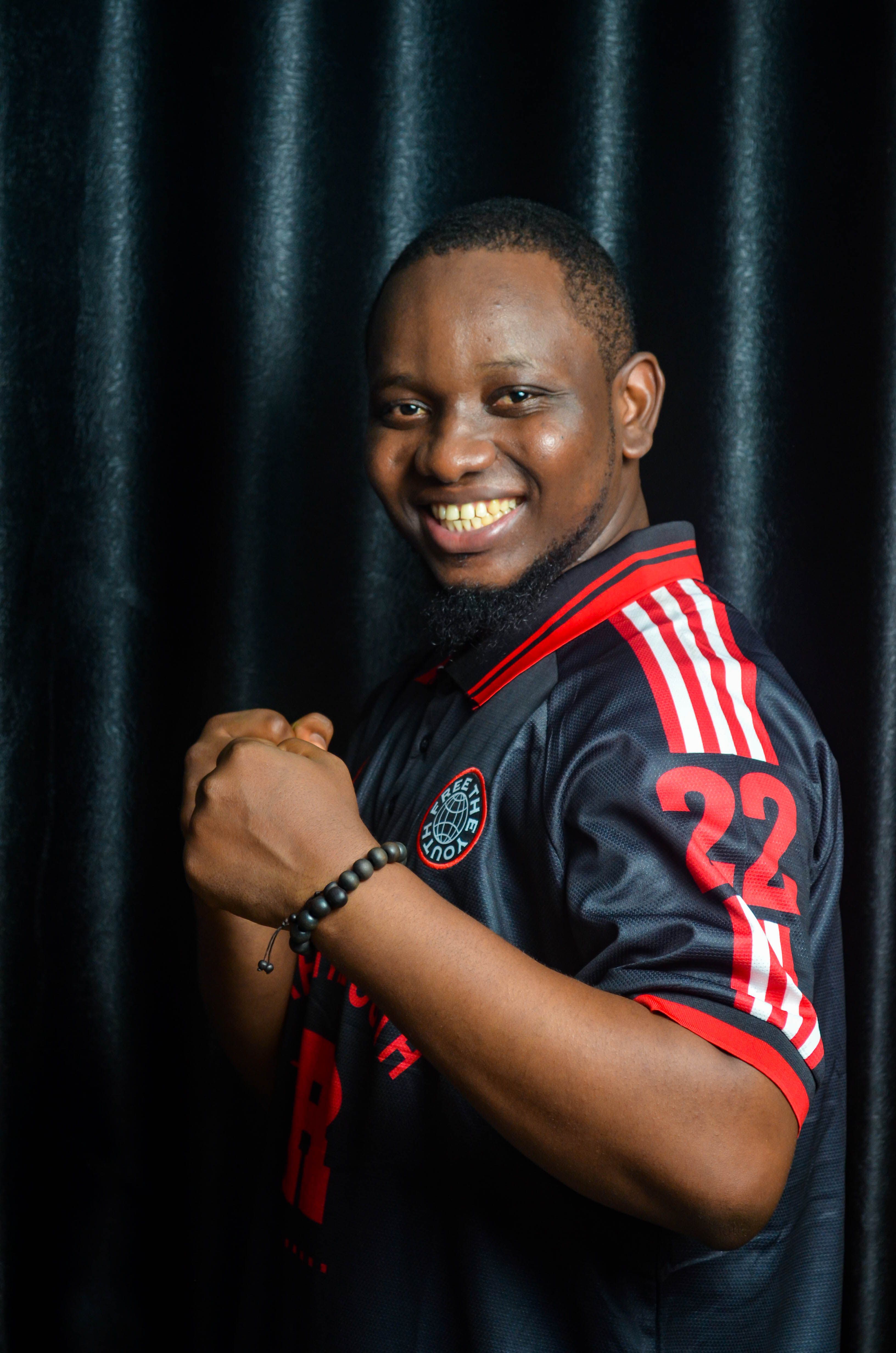 Portrait of a smiling man in a sports jersey, showcasing joy and confidence.