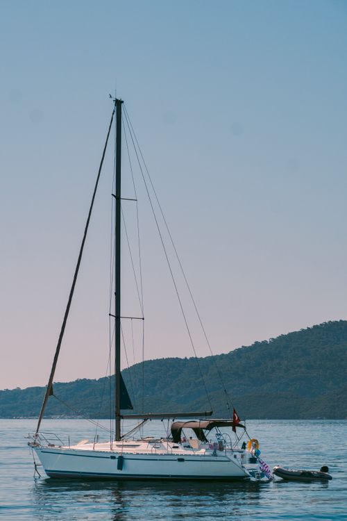 Free A serene image of a sailboat on calm waters in Marmaris, with scenic hills in the background. Stock Photo