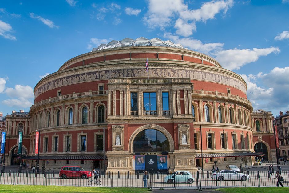 A vibrant image capturing the iconic Royal Albert Hall in London, England under a clear blue sky.