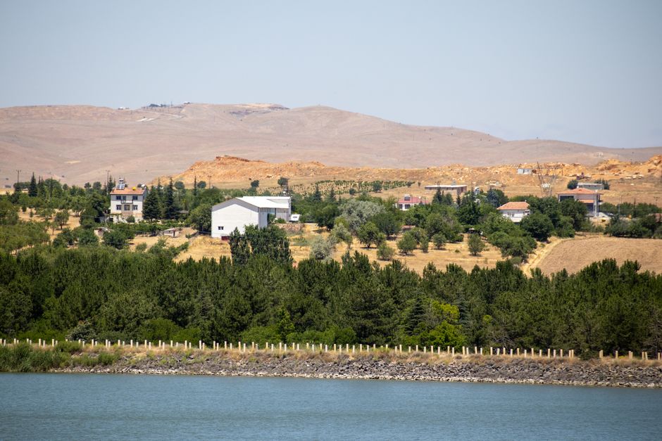 A picturesque view of the Elazığ countryside with green forests and distant hills under a clear sky. in Ghizlane in Visit