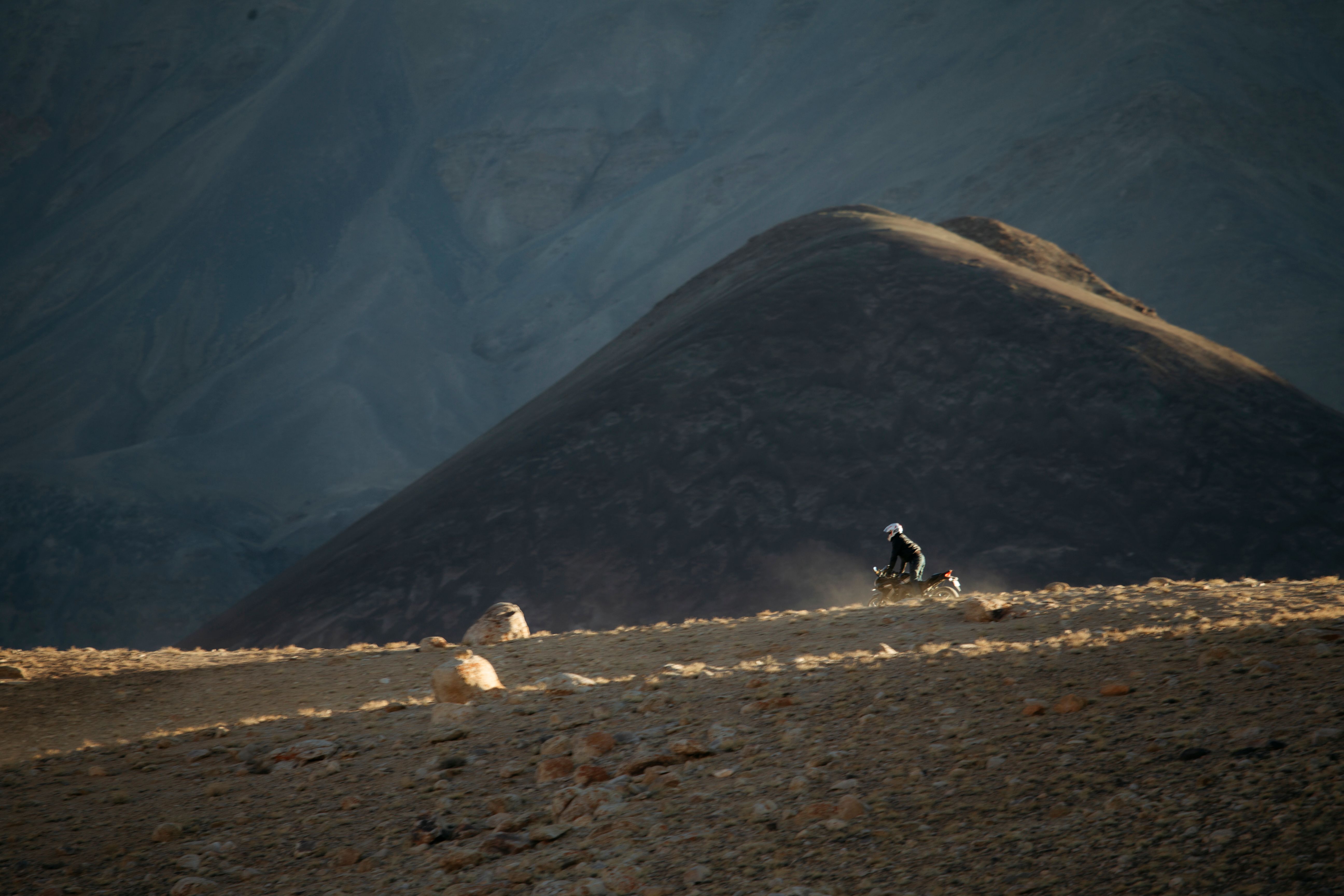 Rider crossing Ladakh's high-altitude landscape on a group bike trip