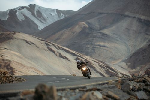 Free Motorcyclist navigating a winding road amid the stunning landscape of the Ladakh mountains in India. Stock Photo