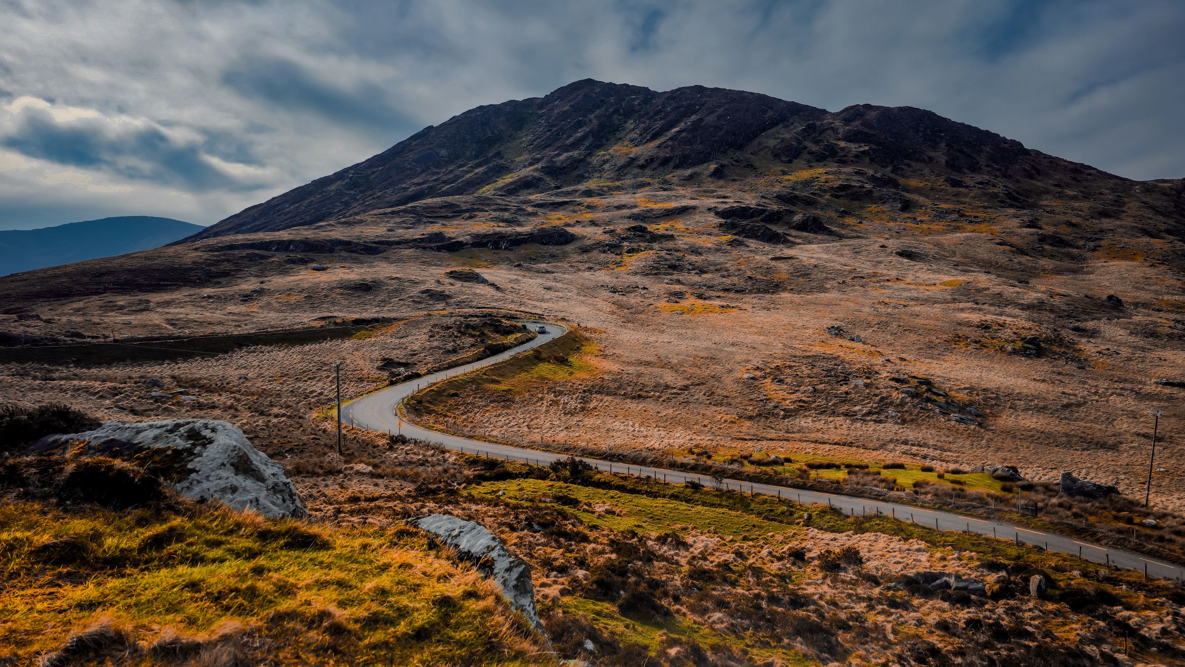 Sweeping view of a winding road through the Irish landscape with rocky hills