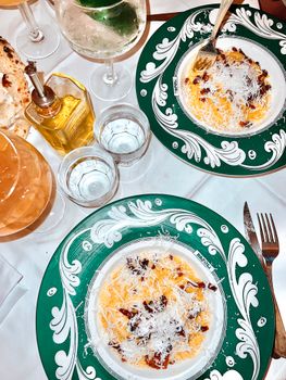 Elegant Italian pasta with parmesan cheese on ornate plates, perfect for fine dining.