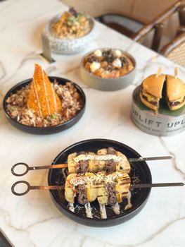 Assorted gourmet skewers and appetizers on a stylish marble table setting, perfect for a food magazine or blog.