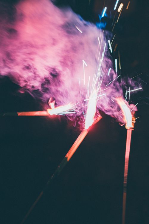 Free Vibrant sparklers creating a dazzling light display against a dark background. Stock Photo
