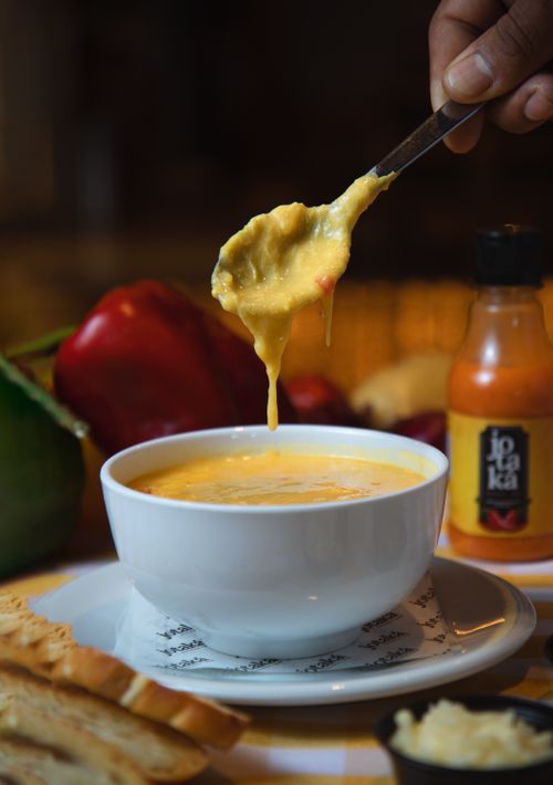 Free Rich cheese fondue with colorful bell peppers, perfect for a cozy dining experience. Stock Photo