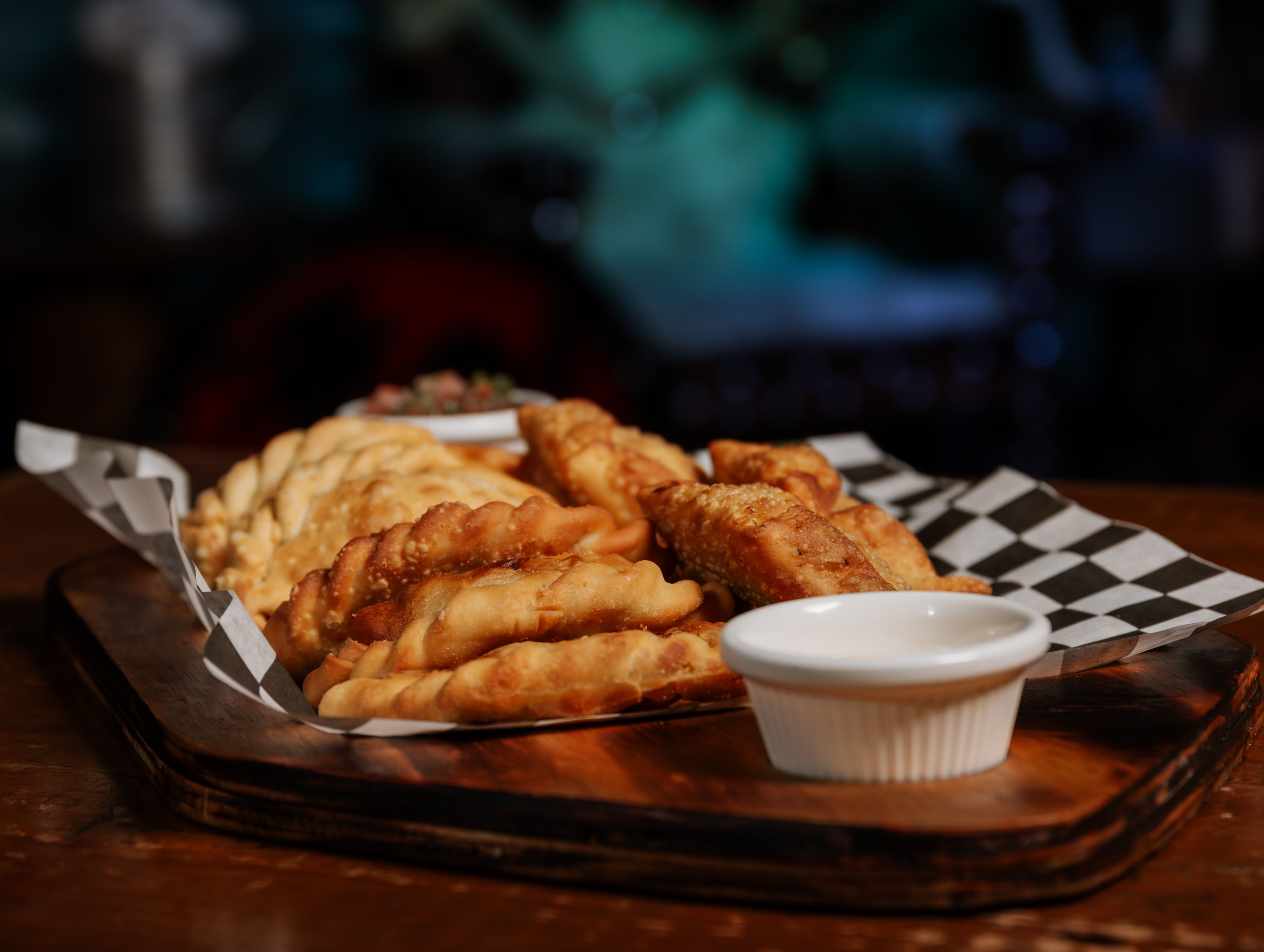 Gratuit Délicieuses empanadas frites disposées sur un plateau en bois avec une sauce à tremper. Photos