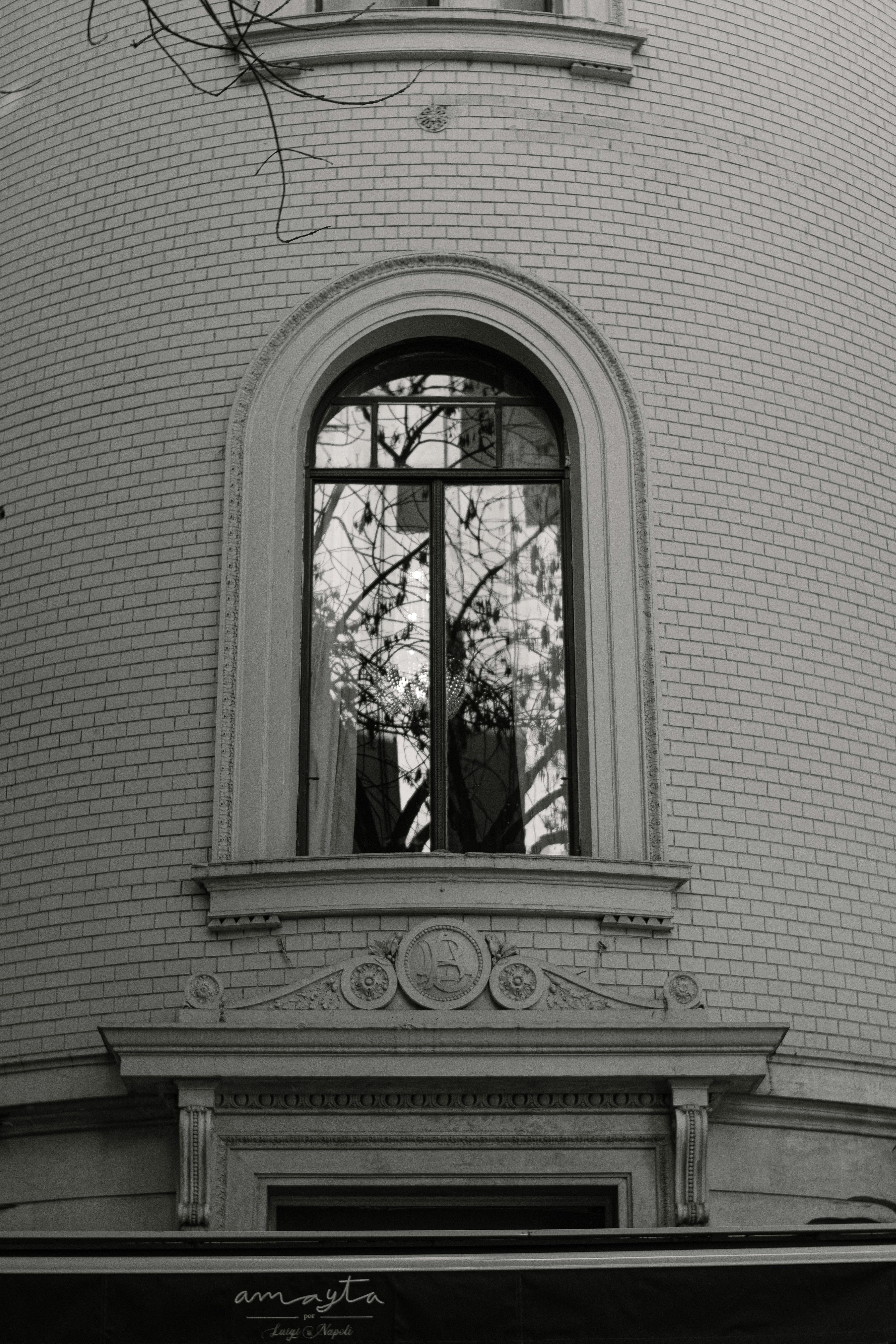 Kostenlos Schwarzweißfoto eines Fensters im europäischen Stil mit Spiegelungen in Buenos Aires. Stock-Foto