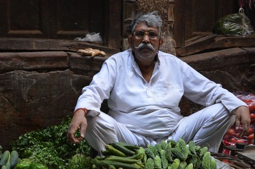 Free A senior man selling fresh vegetables in a bustling Delhi street market. Stock Photo
