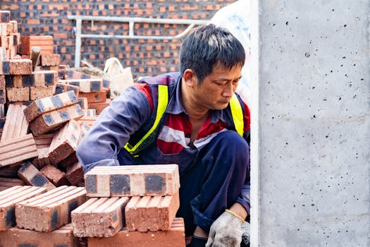 Focused worker laying bricks at construction site in Hải Phòng.
