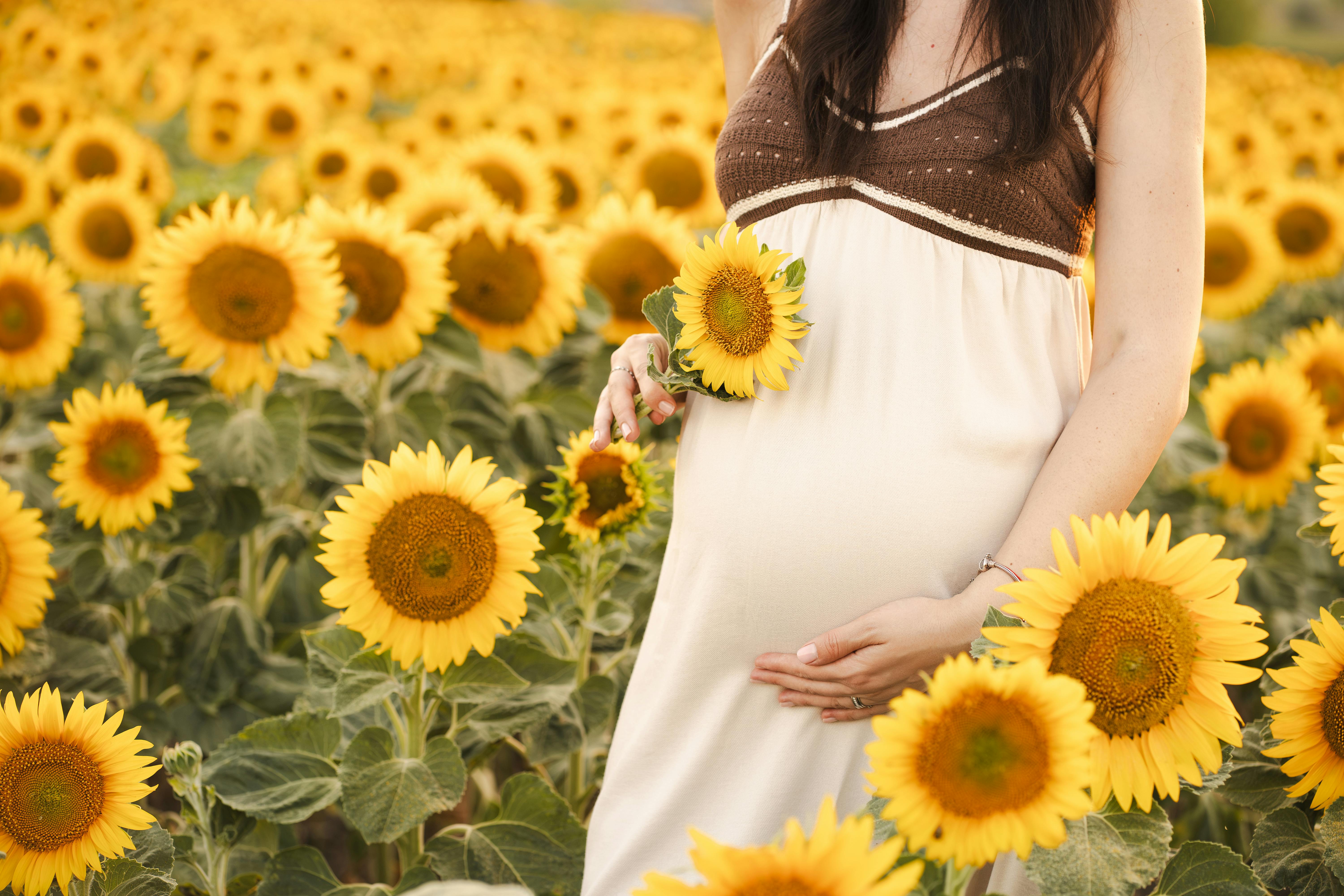 pregnant woman walking briskly on park path, content and healthy