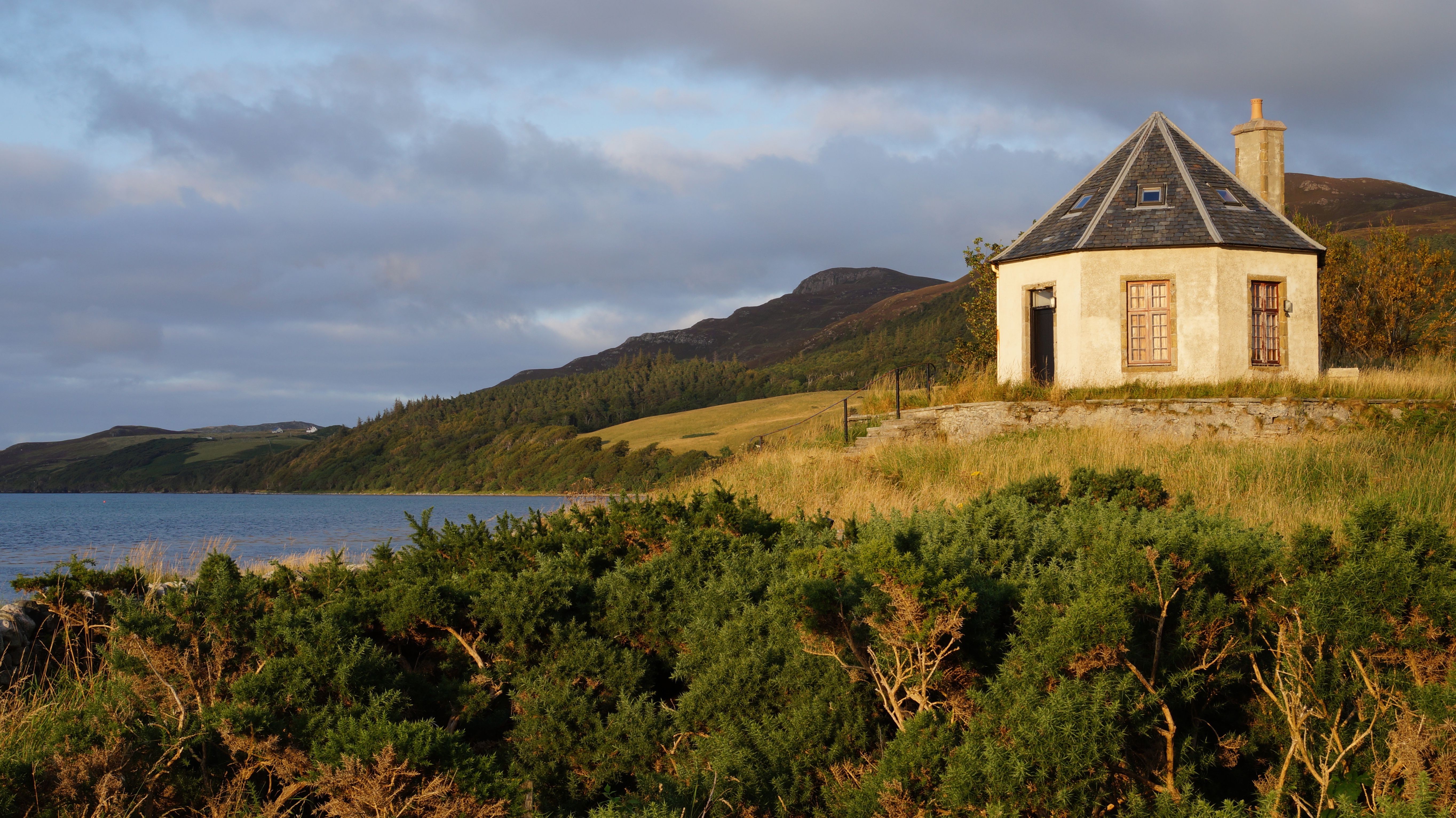A quaint house with a chimney by the sea in the scenic Scottish Highlands.