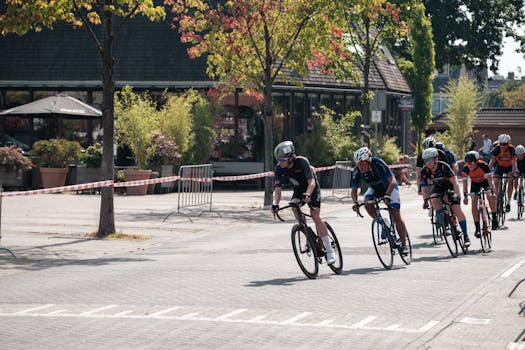 Exciting urban cycling race with athletes in competitive gear speeding through a city street.