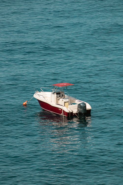 Free A red motorboat anchored on the calm blue waters of the Adriatic Sea near Italy. Stock Photo