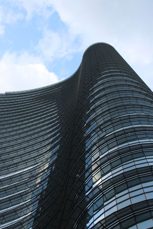 Free Impressive modern skyscraper in Milan, Italy with a sweeping curved design against a blue sky. Stock Photo