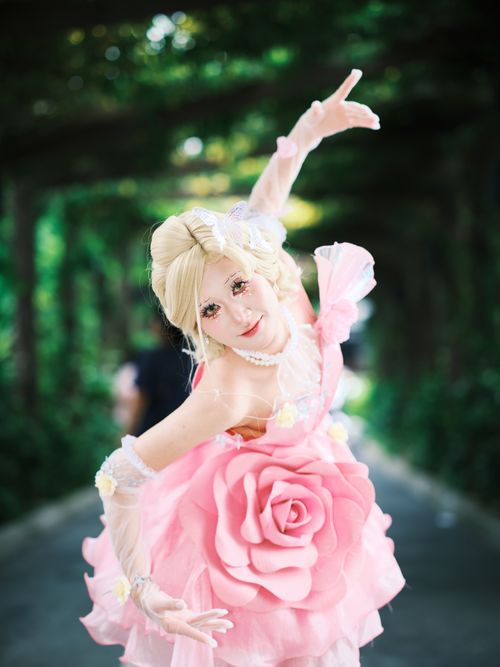 Free A woman in an elegant fairy costume poses gracefully in a lush garden setting. Stock Photo