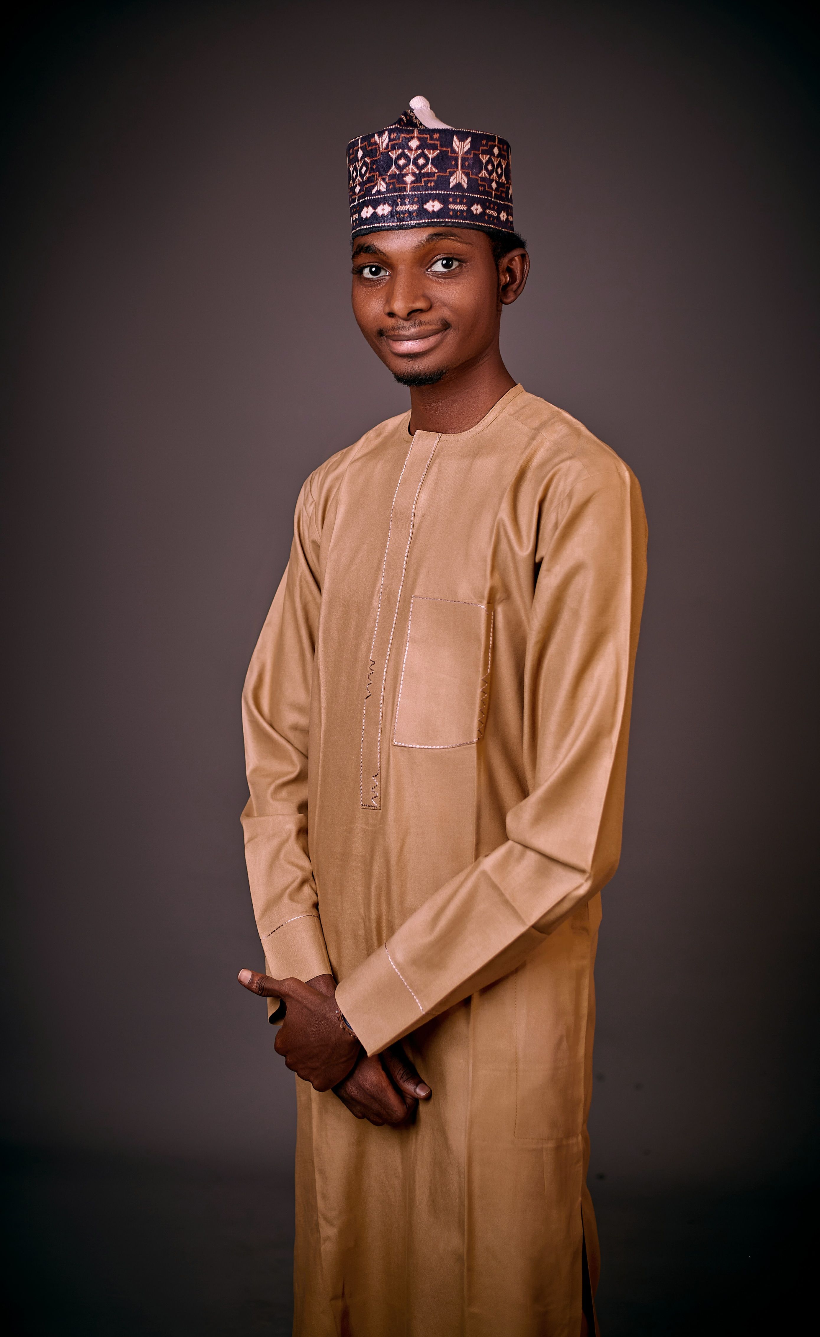 Portrait of a young man wearing traditional clothing, smiling confidently.