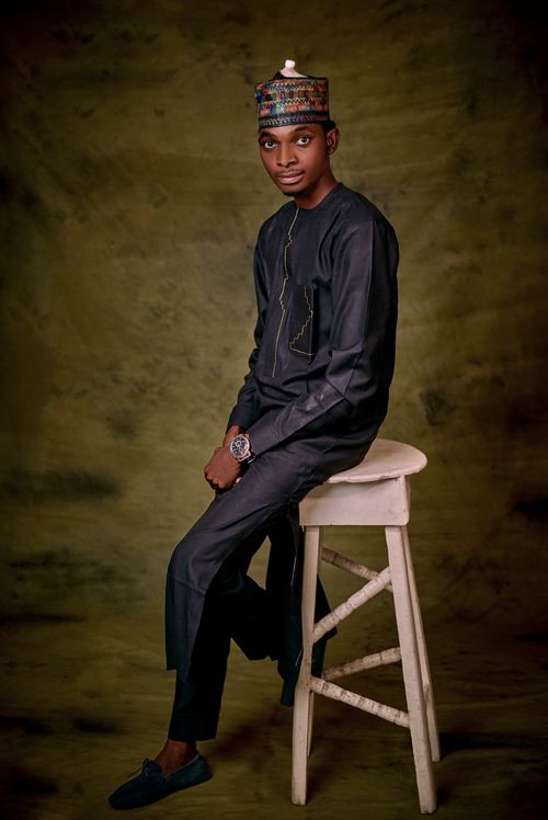 Free Stylish portrait of a man in traditional attire with a beige stool. Stock Photo