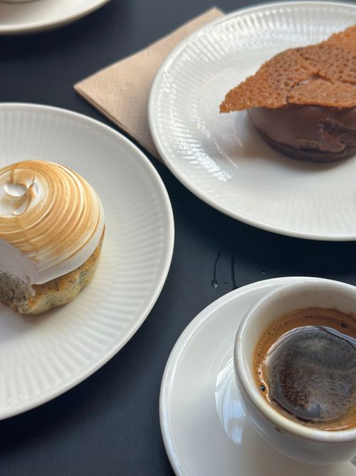 Free A mouthwatering dessert assortment on white plates paired with an espresso cup. Stock Photo
