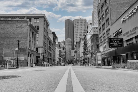 A peaceful street in downtown San Francisco with city skyscrapers under a blue sky.