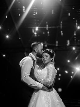 Bride and groom share a tender moment under twinkling lights.